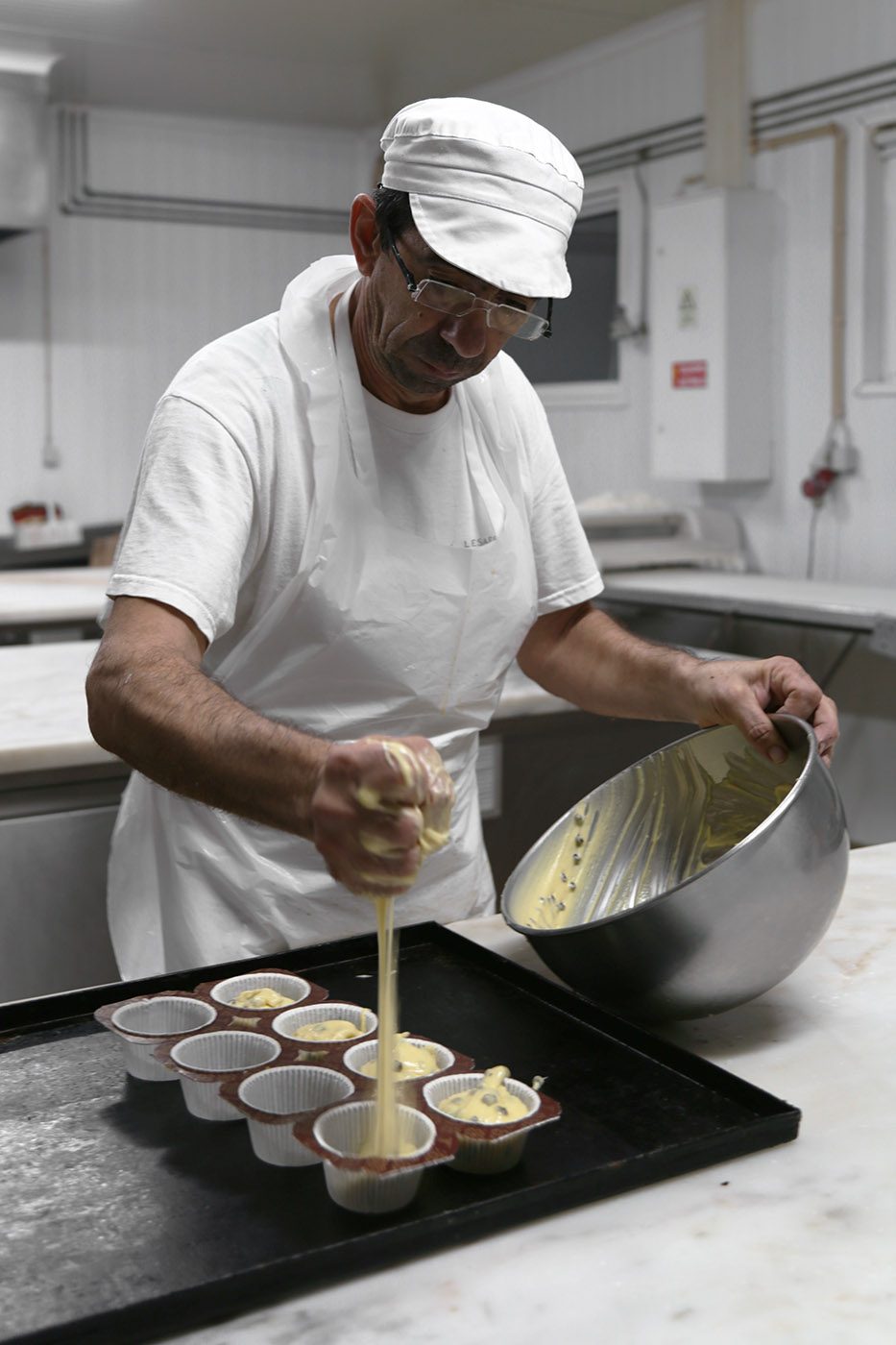 Formas de papel a serem cheias com massa para Muffins. Fábrica de bolos, Odivelas, 2016