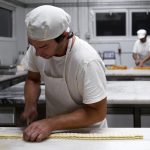 Massa folhada a ser trabalhada para originar miniaturas de Palmieres. Fábrica de bolos, Odivelas, 2016 